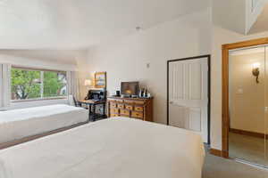 Carpeted bedroom featuring vaulted ceiling and baseboards
