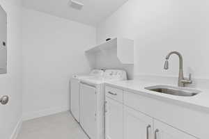 Laundry room with washer and clothes dryer, cabinet space, and baseboards
