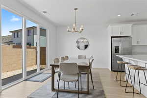 Dining space featuring light wood-style flooring, a chandelier, recessed lighting, and baseboards