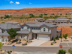 View of front of house with a garage, stucco siding, concrete driveway, stone siding, and a mountain view