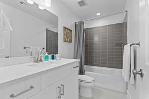Full bath featuring tile patterned floors, toilet, shower / tub combo, and vanity