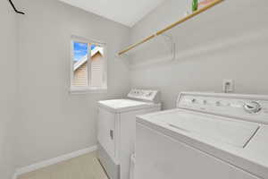 Laundry area with washing machine and dryer and baseboards