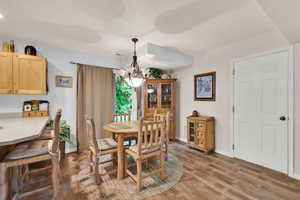 Dining room featuring a chandelier, light wood-type flooring, and baseboards