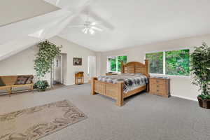 Carpeted bedroom featuring baseboards, vaulted ceiling, a skylight, and a ceiling fan