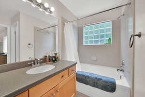 Full bath with shower / bath combination with curtain and vanity