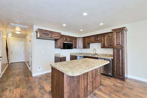Kitchen featuring stainless steel dishwasher, baseboards, dark brown cabinetry, a textured ceiling, and recessed lighting