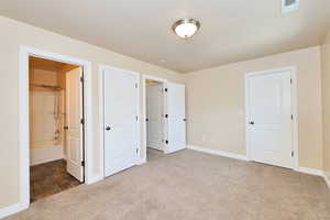 Unfurnished bedroom featuring carpet flooring, baseboards, and ensuite bathroom