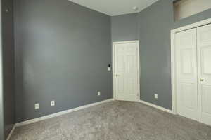 Bedroom featuring carpet flooring, baseboards, and a closet.