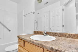 Bathroom with toilet, vanity, and shower / bath combination