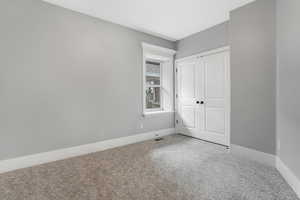 Unfurnished bedroom featuring carpet, baseboards, and a closet.
