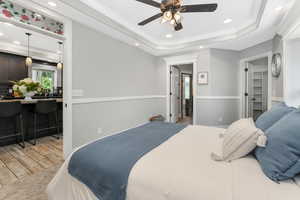Bedroom with ornamental molding, recessed lighting, a tray ceiling, and ceiling fan.
