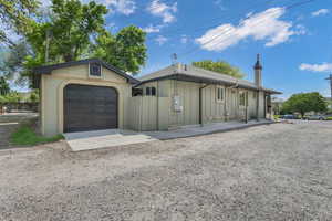 Single story home featuring board and batten siding, a garage, fence, and driveway.