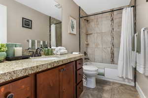 Full bath featuring shower / bath combo with shower curtain, toilet, and vanity.