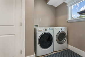 Laundry area featuring washing machine and clothes dryer and baseboards.