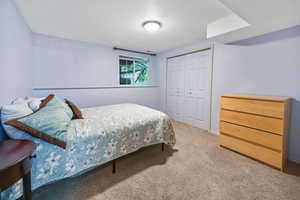 Carpeted bedroom with a closet and baseboards