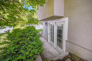 Doorway to property with stucco siding and fence