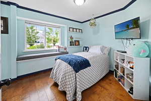 Bedroom with hardwood / wood-style floors and baseboards