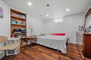 Bedroom with wood finished floors, recessed lighting, and a textured ceiling