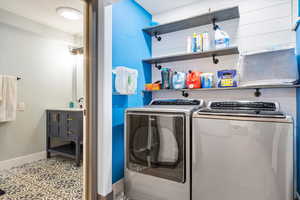 Laundry area with separate washer and dryer and baseboards