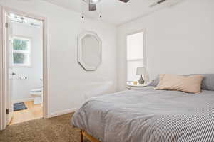 Carpeted bedroom with baseboards and connected bathroom