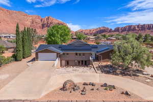 View of front of home with driveway, solar panels, metal roof, a mountain view, and an attached garage