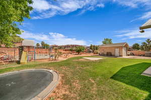 View of yard with a playground, a trampoline, and an outdoor structure