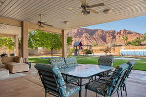 View of patio / terrace with outdoor dining space, a mountain view, ceiling fan, outdoor lounge area, and a playground