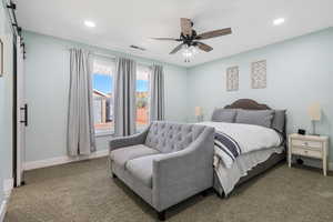 Bedroom with recessed lighting, a barn door, carpet flooring, baseboards, and a ceiling fan