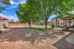 View of yard featuring fence, a playground, and a patio area
