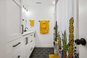 Bathroom featuring tile patterned flooring, vanity, baseboards, and a shower with curtain