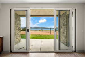 Doorway featuring plenty of natural light, a water view, and wood finished floors