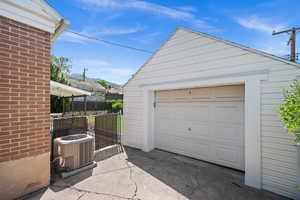 Detached garage with central AC, fence, a mountain view, and driveway