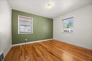 Empty room with wood-type flooring and baseboards
