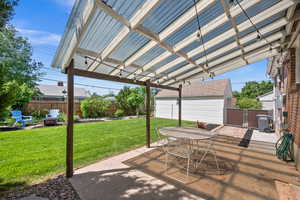 View of patio featuring a fire pit, central AC, outdoor dining space, and an outbuilding