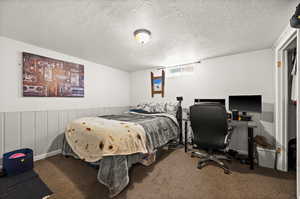 Bedroom featuring carpet and a textured ceiling