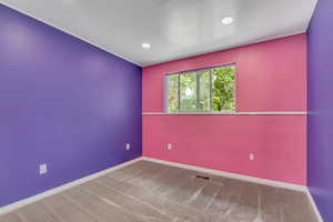 Carpeted spare room with baseboards and recessed lighting