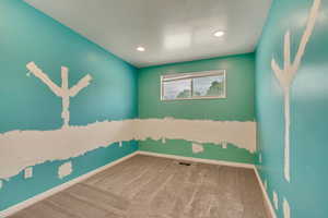 Carpeted empty room with baseboards and recessed lighting