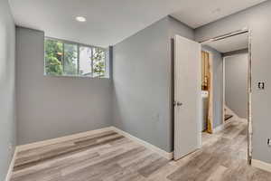 Empty room with wood finished floors, baseboards, recessed lighting, washer / clothes dryer, and stairway