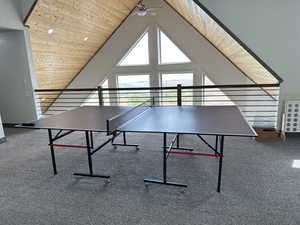 Rec room featuring ceiling fan, wooden ceiling, carpet flooring, and lofted ceiling