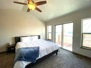 Bedroom featuring access to outside, vaulted ceiling, carpet flooring, and multiple windows