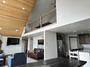 Living room with high vaulted ceiling, wooden ceiling, recessed lighting, a ceiling fan, and wood finished floors