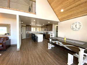 Dining space with high vaulted ceiling, baseboards, dark wood-type flooring, recessed lighting, and wooden ceiling