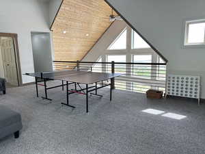 Recreation room with high vaulted ceiling, a ceiling fan, wooden ceiling, and baseboards