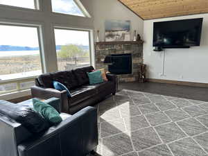 Living room with lofted ceiling, wooden ceiling, wood finished floors, a fireplace, and baseboards