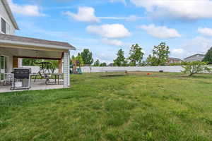 View of yard with a playground, a patio, a ceiling fan, and a trampoline