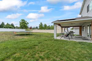 View of yard featuring a trampoline, a patio, and ceiling fan