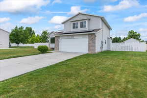 View of front of property featuring an attached garage, driveway, and brick siding