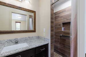 Full bath with a tile shower and vanity