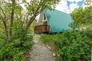 View of side of property with a deck and metal roof