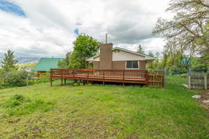 Rear view of property with a wooden deck and a chimney